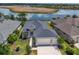 Aerial view of a beautifully landscaped home with a large driveway and stunning views of a tranquil lake at 8664 Bridgeport Bay Cir, Mount Dora, FL 32757