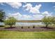 Backyard view with waterfront access, landscaping, mulch and manicured lawn at 8664 Bridgeport Bay Cir, Mount Dora, FL 32757