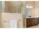Modern bathroom with glass-enclosed shower and vanity with dual sinks at 8664 Bridgeport Bay Cir, Mount Dora, FL 32757