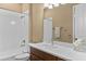 Bright bathroom featuring a tub with shower, white tiling, and wood vanity with white countertop at 8664 Bridgeport Bay Cir, Mount Dora, FL 32757