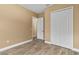 Bedroom with wood-look tile flooring, bi-fold closet doors, and a view to an adjacent doorway at 8664 Bridgeport Bay Cir, Mount Dora, FL 32757