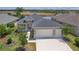 Charming single-Gathering home features a two-car garage, manicured lawn, and picturesque lake view at 8664 Bridgeport Bay Cir, Mount Dora, FL 32757