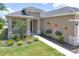 Charming home exterior with a well-manicured lawn, stone accents, and decorative floral accents at 8664 Bridgeport Bay Cir, Mount Dora, FL 32757
