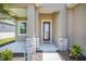 Close-up of a charming front porch featuring stone pillars and a decorative front door at 8664 Bridgeport Bay Cir, Mount Dora, FL 32757