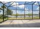 Enclosed lanai featuring a view of the water, green space, and nearby vegetation at 8664 Bridgeport Bay Cir, Mount Dora, FL 32757