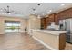 Bright living room featuring modern lighting, tile floors, neutral walls, and scenic lake views through sliding glass doors at 8664 Bridgeport Bay Cir, Mount Dora, FL 32757