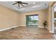 Open floorplan, sliding glass doors to a patio, neutral colored walls, and tile floors can be seen throughout the living room at 8664 Bridgeport Bay Cir, Mount Dora, FL 32757