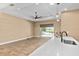 This living room has tile floors, neutral colored walls, modern lighting, and sliding glass doors to the patio at 8664 Bridgeport Bay Cir, Mount Dora, FL 32757