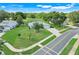 Aerial view of single-Gathering home near a golf course with lush landscaping and mature trees at 8709 Augusta Ct, Clermont, FL 34711