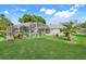 View of a screened-in pool in the backyard with lush lawn and landscaping at 8709 Augusta Ct, Clermont, FL 34711