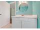 Bathroom with a single sink vanity, a round mirror, and a door leading to another room at 8709 Augusta Ct, Clermont, FL 34711
