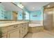 Bright bathroom with a double sink vanity, a soaking tub, and a glass-enclosed shower at 8709 Augusta Ct, Clermont, FL 34711