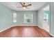 Bedroom with wood floors, ceiling fan, and a window providing lots of natural light at 8709 Augusta Ct, Clermont, FL 34711