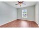 A light filled bedroom showcases hardwood floors and a window with white blinds at 8709 Augusta Ct, Clermont, FL 34711