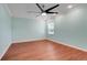 This bedroom has hardwood floors, a ceiling fan, and a window providing natural light at 8709 Augusta Ct, Clermont, FL 34711