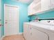 Bright laundry room features a modern washer and dryer, white storage cabinets, and a tiled floor at 8709 Augusta Ct, Clermont, FL 34711