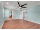 Spacious living room with hardwood floors, a ceiling fan, and access to other rooms at 8709 Augusta Ct, Clermont, FL 34711