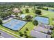 High angle showcasing the tennis courts, golf course, clubhouse, pool, and surrounding neighborhood at 9010 Laurel Ridge Dr, Mount Dora, FL 32757