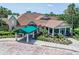 Beautiful exterior featuring a porte-cochere, lush landscaping, and manicured grounds at 9010 Laurel Ridge Dr, Mount Dora, FL 32757