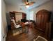 Well-lit home office featuring rich hardwood floors, custom built-ins, and a large wooden armoire at 9010 Laurel Ridge Dr, Mount Dora, FL 32757