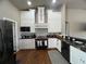 Charming kitchen featuring custom white cabinetry, modern appliances, and elegant black countertops at 9010 Laurel Ridge Dr, Mount Dora, FL 32757