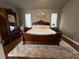 Main bedroom suite featuring wood floors, natural light, and an oversized ornate headboard at 9010 Laurel Ridge Dr, Mount Dora, FL 32757