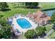 Aerial view of the community pool and clubhouse with tennis courts and a golf course in the background at 9010 Laurel Ridge Dr, Mount Dora, FL 32757