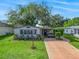 Charming home featuring a well-manicured lawn, covered porch, and mature landscaping for inviting curb appeal at 941 Tarrson Blvd, Lady Lake, FL 32159