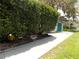 Well-maintained home exterior with mature landscaping, concrete driveway and a peek at the green garage at 941 Tarrson Blvd, Lady Lake, FL 32159