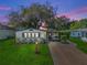Charming home exterior at dusk with lush green lawn and inviting carport area at 941 Tarrson Blvd, Lady Lake, FL 32159