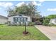 Charming single-story home with manicured lawn, covered parking, and cozy front garden at 941 Tarrson Blvd, Lady Lake, FL 32159