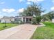 Charming home with lush green lawn, convenient carport, and tidy front garden at 941 Tarrson Blvd, Lady Lake, FL 32159
