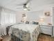 Relaxing main bedroom features a fan, a bed with stylish bedding, and white dressers at 941 Tarrson Blvd, Lady Lake, FL 32159