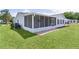 Rear exterior view showcasing the enclosed patio and well-maintained lawn at 9461 Se 173Rd Ln, Summerfield, FL 34491