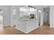 Open-concept kitchen view with a breakfast bar, stainless steel appliances, and bright white cabinets at 9461 Se 173Rd Ln, Summerfield, FL 34491