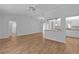 Bright living room with wood-look flooring, ceiling fan, and view into kitchen at 9461 Se 173Rd Ln, Summerfield, FL 34491