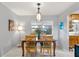 Bright dining room with a wooden table set for four, complemented by a stylish light fixture at 9752 County Road 121, Wildwood, FL 34785