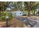 Charming single-story home featuring a driveway, light blue exterior paint and mature landscaping at 9752 County Road 121, Wildwood, FL 34785