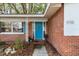 Charming front entrance with blue door, shutters, and brick facade, showcasing a welcoming curb appeal at 9752 County Road 121, Wildwood, FL 34785