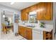 Practical kitchen with wooden cabinets, a bright window, and a view into the adjacent dining area at 9752 County Road 121, Wildwood, FL 34785