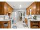 Functional kitchen features wooden cabinetry, white appliances and tile flooring with view into dining area at 9752 County Road 121, Wildwood, FL 34785