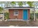 Charming shed with a vibrant blue door nestled in a private backyard setting at 9752 County Road 121, Wildwood, FL 34785