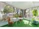Bright sunroom featuring wicker furniture and a vertical garden with lush plants at 9752 County Road 121, Wildwood, FL 34785