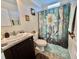 Bathroom featuring a decorative shower curtain with a white flower design and a spacious sink countertop at 102 Dogwood Trl, Leesburg, FL 34748