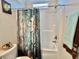 Bright bathroom featuring a shower-tub combo with a unique flower-patterned shower curtain at 102 Dogwood Trl, Leesburg, FL 34748