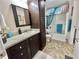 Well-maintained bathroom with dark wood cabinets, granite countertops, and a shower with glass doors at 102 Dogwood Trl, Leesburg, FL 34748