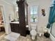 Bright bathroom featuring dark wood vanity and cabinets, toilet, decor, and tile floors at 102 Dogwood Trl, Leesburg, FL 34748