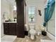 Well-lit bathroom with a spacious vanity and a decorative shower curtain, next to a toilet with art on the wall at 102 Dogwood Trl, Leesburg, FL 34748