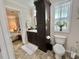 Well-lit bathroom with dark wood cabinetry, and access to the bedroom at 102 Dogwood Trl, Leesburg, FL 34748
