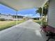 Exterior view of a covered carport with bench and golf cart parking at 102 Dogwood Trl, Leesburg, FL 34748